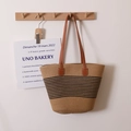 Straw tote bag with black stripes and brown leather handles hanging on a wooden wall hook - Fine Stripes With Strap