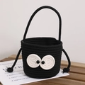 Handmade black woven bucket bag with large eye accents and a sturdy carrying handle - Black Coal Sprite