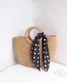 Detailed view of handmade straw handbag featuring a polka dot silk scarf and round handles - Coffee + Black Polka Dot Scarf