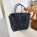Chic black woven tote bag with a hollow cross-stitch pattern for beach vacations - Black