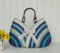 Dettaglio borsa in paglia intrecciata colorata con pizzo e manici in legno tondi - Righe Blu