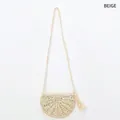Détail d'un sac bandoulière beige en paille fait main avec pompons et texture tissée - Beige
