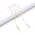 Dettaglio catena per occhiali dorata con perle bianche, moschettoni e anelli in silicone - Oro Motivo Perla 1:2:3