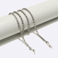 Zilveren metalen brillenkoord met siliconen lussen op een minimalistische witte standaard - Zilver