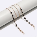 Minimalist gold eyeglasses chain with black beads wrapped on white cylinder display - Gold Chain With Black Beads / Gold