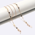 Cadena dorada para gafas con colgantes de corazón y lazos de silicona sobre fondo blanco - Corazón Hueco Dorado (GL1598) / Dorado