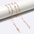 Elegant gold glasses chain with rhinestones and white silicone loops on display - Gold