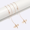 Elegante gouden metalen brillenketting met holle libelle hangers op een witte display - Goud
