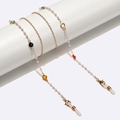 Catenina per occhiali dorata con pietre colorate e perle bianche su espositore bianco - Stile con Perline Dorate (GL1548)