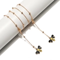 Golden eyewear chain with metal beads and yellow bee pendants on a white stand - Gold