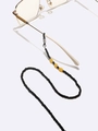 Handmade beaded glasses chain with black beads and amber accents on white background - Black With Amber Accents