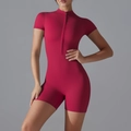 Detail view of the high-stretch fabric and zipper design on a dark red yoga romper - S / Carmine