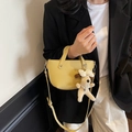 Dettaglio borsa gialla texture litchi con ciondolo a forma di cucciolo e fibbie argento - Senza Ciondolo / Giallo