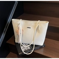 Dettaglio della borsa tote bianca trapuntata con targhetta in metallo e ciondolo orso - Bianco Sporco