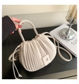 Detail view of the vertical pleated texture and leather handle on the beige bucket bag - White