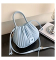 Close-up of light blue pleated bucket bag with leather texture and gold metal hooks - Blue