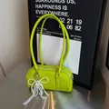 Fluorescent green Boston bag with pearl bow and lace charm on a metallic table - Fluorescent Green (With Pearl Lace Pendant)