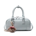Sac Boston bleu clair en cuir texturé avec charm en peluche sur fond blanc épuré - Avec Pendentif / Bleu