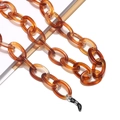 Macro view of amber acrylic eyewear chain with tortoise texture and black rubber loops - Amber Texture (7)