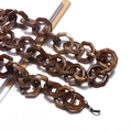 Detail of amber acrylic glasses chain with hexagonal links and marble texture - Two-tone Coffee (Amber Marble)