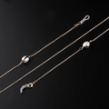 Catenina per occhiali dorata con perle d'acqua dolce e terminali in silicone su nero - Stile Perla Dorata (GL952)