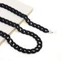 Nahaufnahme der mattschwarzen Brillenkette aus Acryl mit silbernen Clips auf Buch - Schwarz