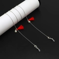 Catena per occhiali in metallo argento con nappe rosse e perle bianche su fondo nero - Stile Catena Argento Nappa Rossa Perla