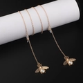 Cadena para gafas en oro rosa con colgantes de abeja y perlas sobre fondo negro - Oro Rosa (GL930)
