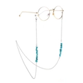 Golden metal eyewear chain with turquoise stone beads on glasses against white background - Silver
