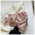 Close-up of pink pleated cloud bag with pearl chain strap and soft leather texture - Pink