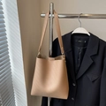 Minimalist light brown pebbled leather bucket bag with elegant golden hardware details - Khaki