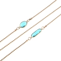 Detail of gold beaded chain featuring vibrant sky blue acrylic crystal gemstones - Cyan