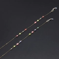 Fashionable gold evil eye eyeglass chains with colorful beads on a black background - Default