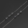 Elegante catena in metallo argento con perline quadrate in marmo grigio su sfondo nero - Perle Motivo Marmo / Argento