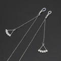 Silver metal eyewear chain with triangle pendant and white pearls on dark background - Silver