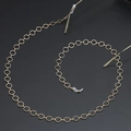Cadena de gafas minimalista en oro con bucles de silicona antideslizantes sobre fondo negro - Dorado