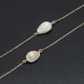 Minimalist gold eyewear chain featuring natural white seashells and metallic links - Gold