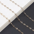 Gepolijste gouden ketting met ronde metalen schakels op een zwart-witte achtergrond - Goud