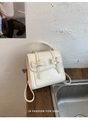 Gros plan du sac à dos en cuir PU crème avec nœuds papillon et détails de lettrage gaufrés - Blanc