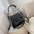 Bolso de PVC transparente negro con bolsa interna y detalles dorados en sofá - Negro