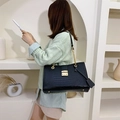 Chic black crocodile embossed tote bag with gold chain strap in minimalist interior - Black