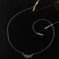 Cadena de plata para gafas con dijes de ala y paz sobre fondo negro reflectante - Estilo Alas Signo de la Paz / Plateado
