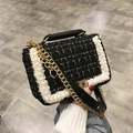 Schwarze Tweed-Umhängetasche mit weißen Perlen und goldener Kette in der Hand - Schwarz
