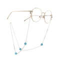 Goldene runde Brille mit feiner Metallkette und hellblauen Katzenaugen-Perlen verziert - Gold mit blauen Katzenaugenperlen