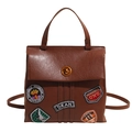 Dark brown retro leather backpack with vintage American embroidery badges and metal clasp - Brown