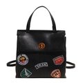 Retro black leather backpack with colorful fashion badges and a vintage brass twist lock - Black