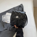 Mini black quilted backpack featuring a glossy finish with silver metal turn-lock closure - Black