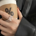 Primo piano dell'anello geometrico in argento lucido indossato da modella con caffè - Stile Linee Geometriche Argento (J2332)