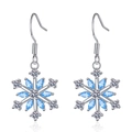 Boucles d'oreilles flocon de neige avec zircons bleus et monture argentée sur fond blanc - Zircone Bleue