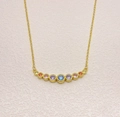 Detail view of gold necklace featuring nine vibrant rainbow gemstones in a curved pendant - Gold Color (XL0078)